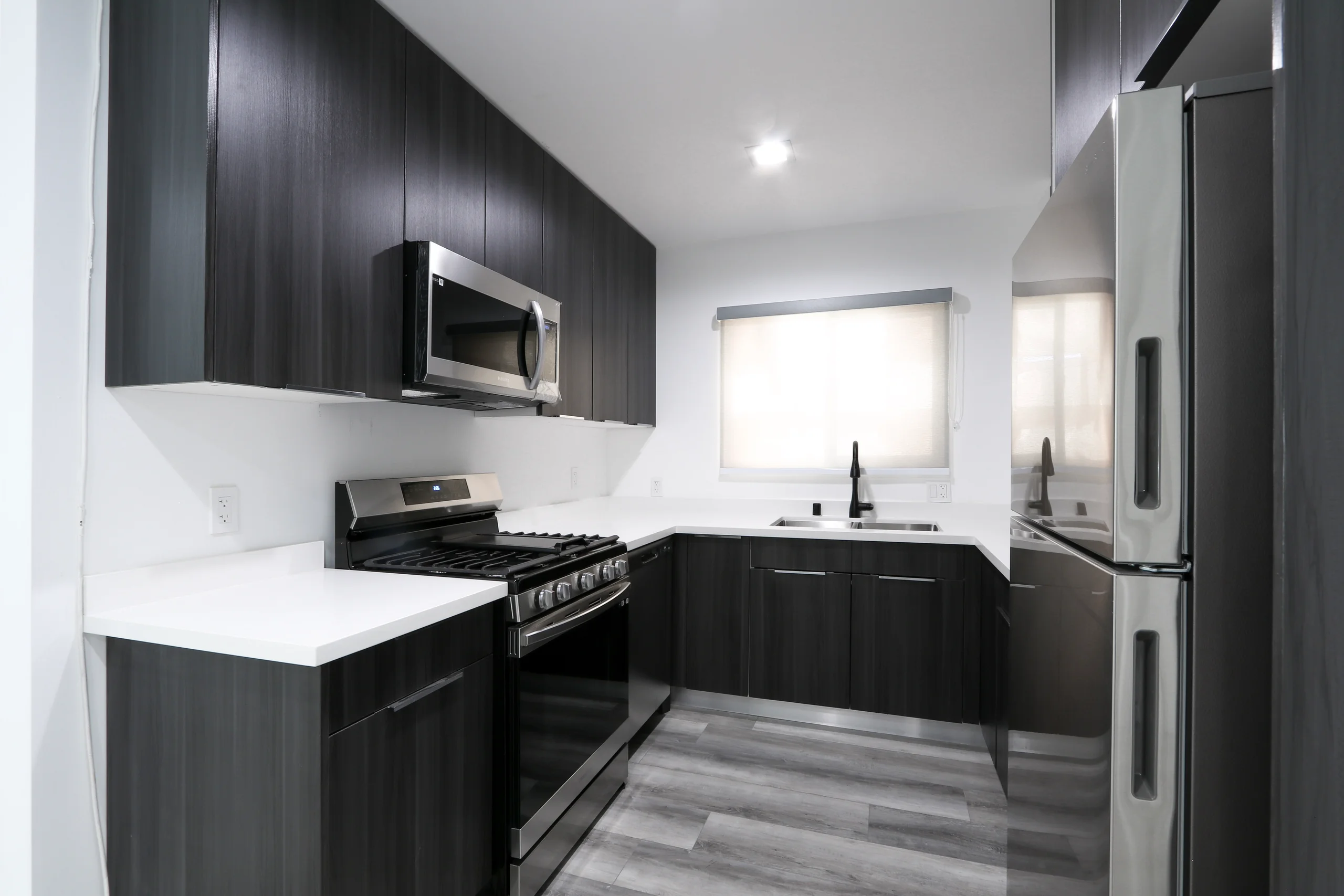 Modern kitchen with stainless steel appliances and sleek granite countertops. (photo 1 of 21)