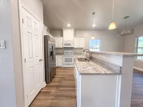 Modern kitchen with stainless appliances and granite countertops. (photo 2 of 5)