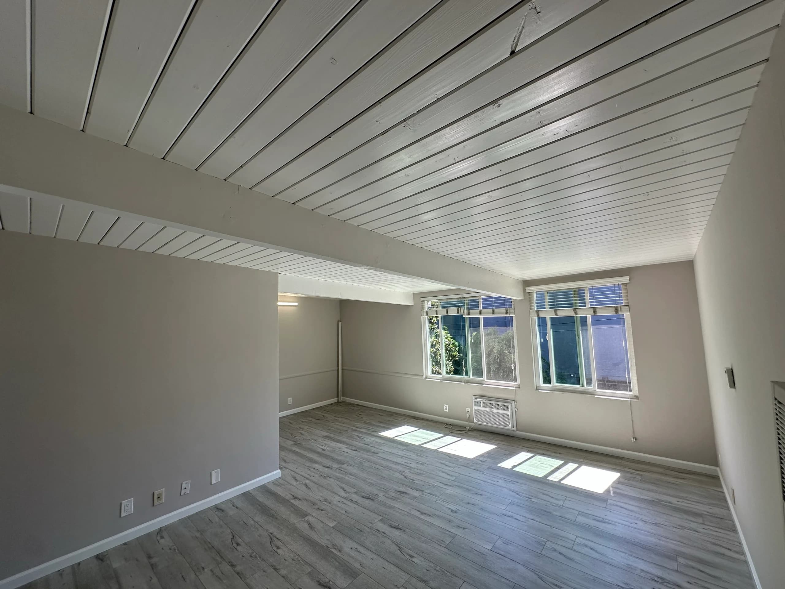 Spacious living room with hardwood flooring and ample natural light. (photo 2 of 16)