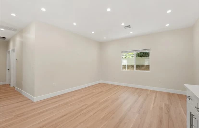 Spacious living room with hardwood flooring and natural light. (photo 2 of 9)