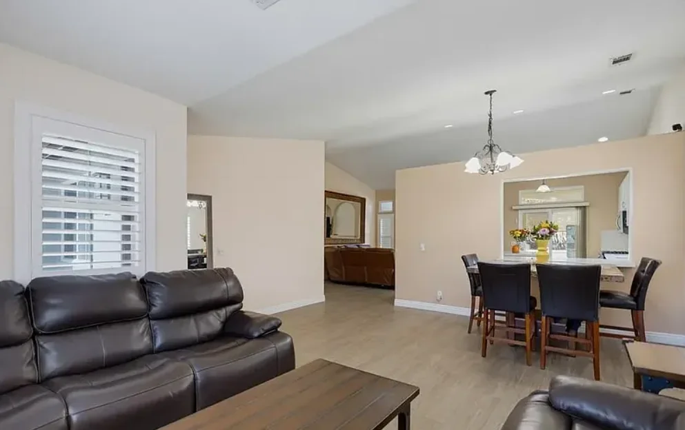 Open living room featuring hardwood flooring and a breakfast bar area. (photo 2 of 5)