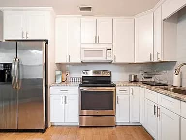 Modern kitchen with stainless steel appliances and granite countertops. (photo 2 of 8)