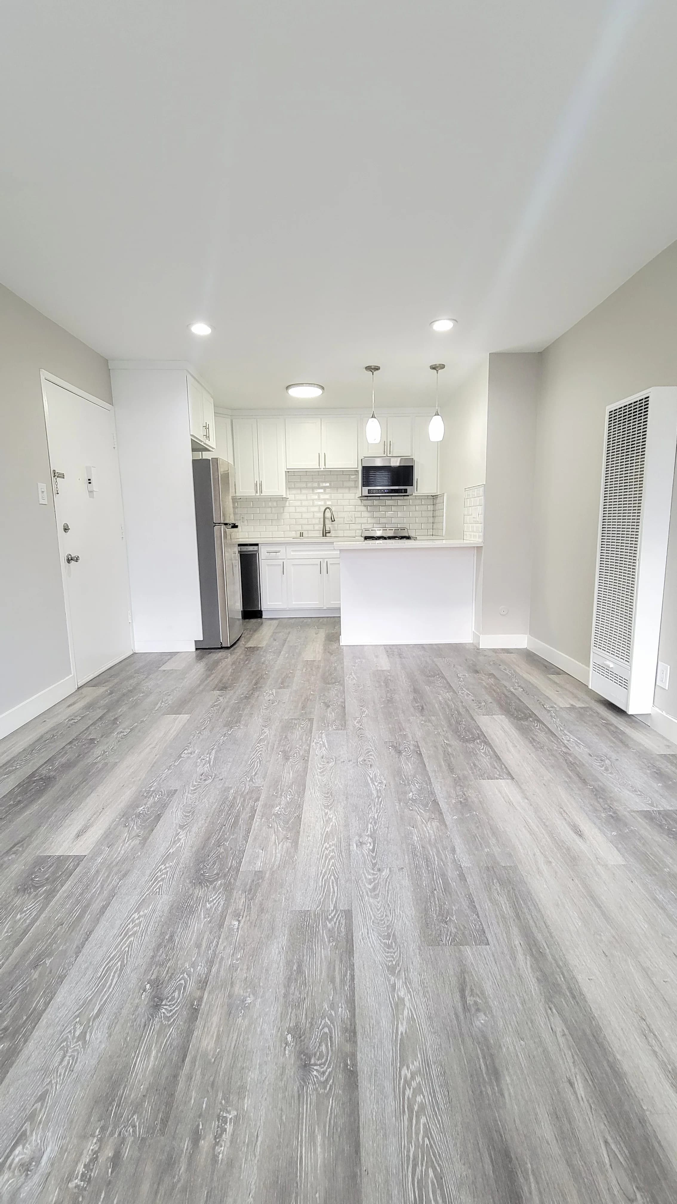 Spacious living area with modern kitchen and stainless appliances. (photo 2 of 16)