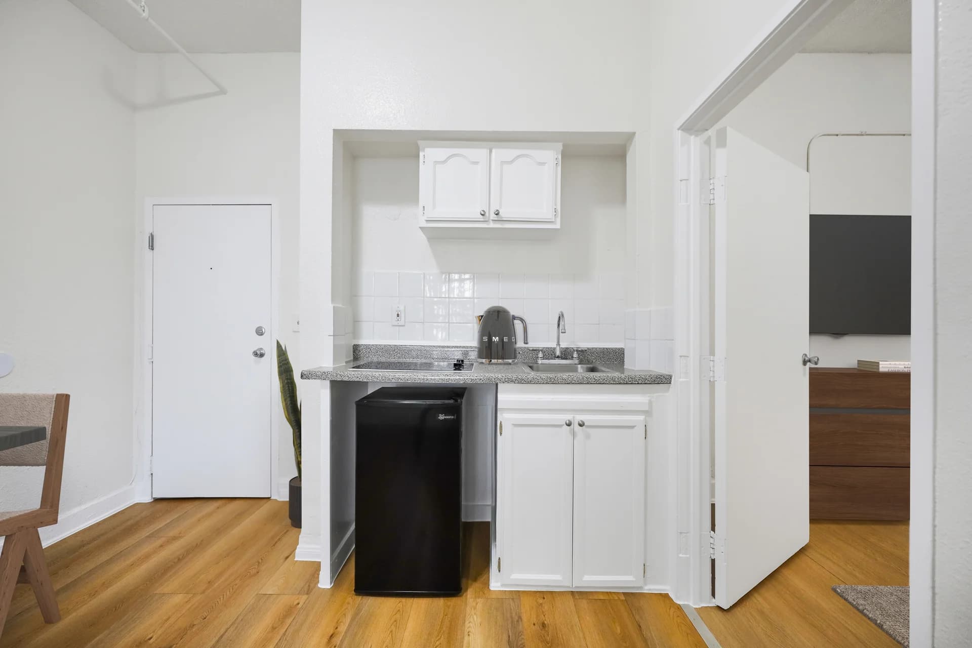 Compact kitchen area featuring granite countertops and stainless appliances. (photo 2 of 25)