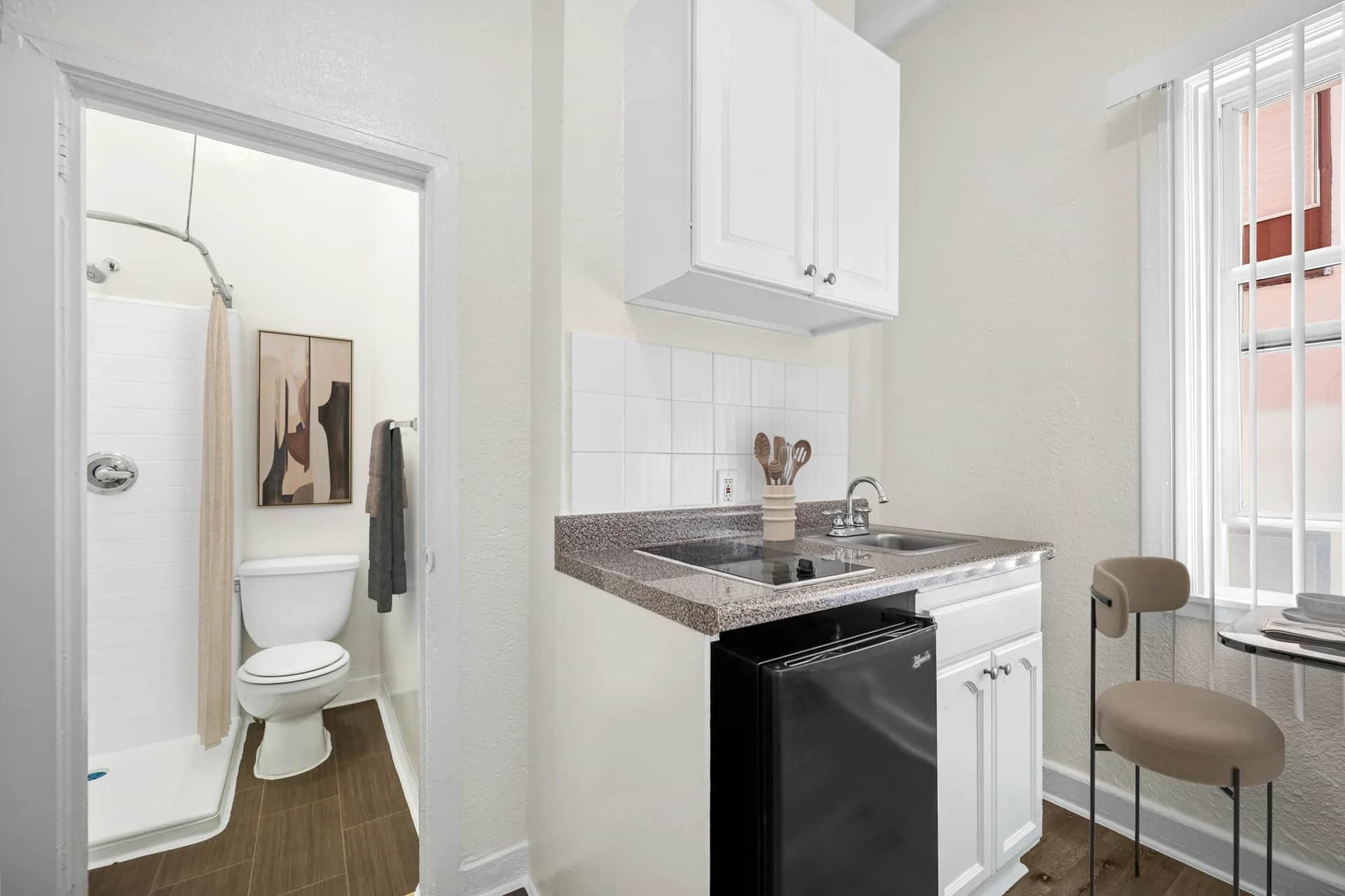 Compact kitchenette area with stainless appliances and a bathroom accessible nearby. (photo 1 of 25)