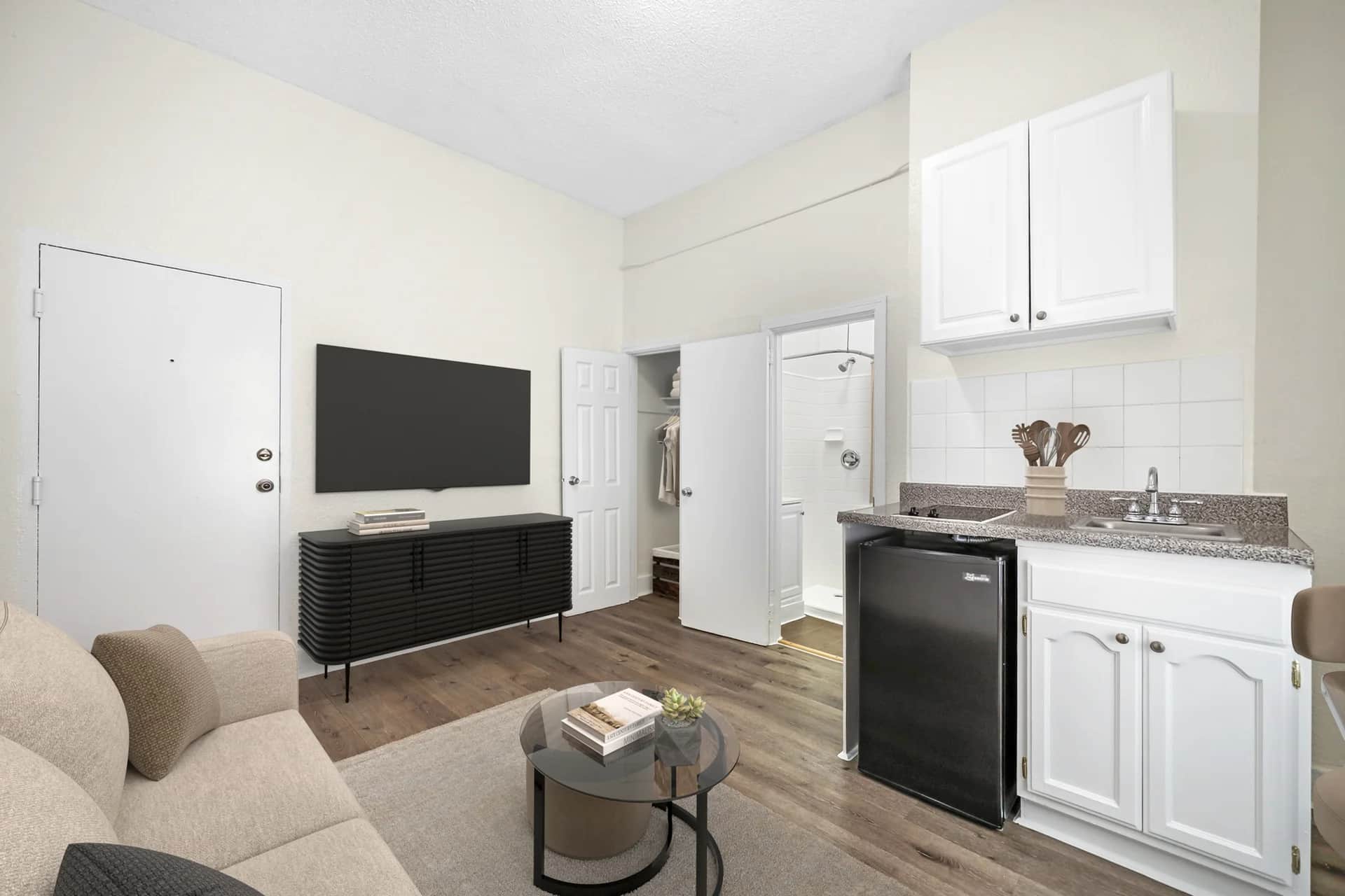 Cozy living room area featuring hardwood flooring and a kitchenette. (photo 1 of 25)