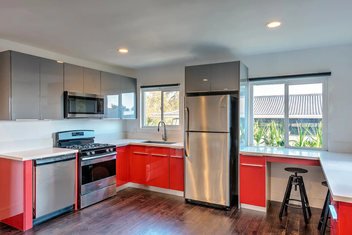 Modern kitchen featuring stainless steel appliances and sleek red cabinetry. (photo 2 of 21)