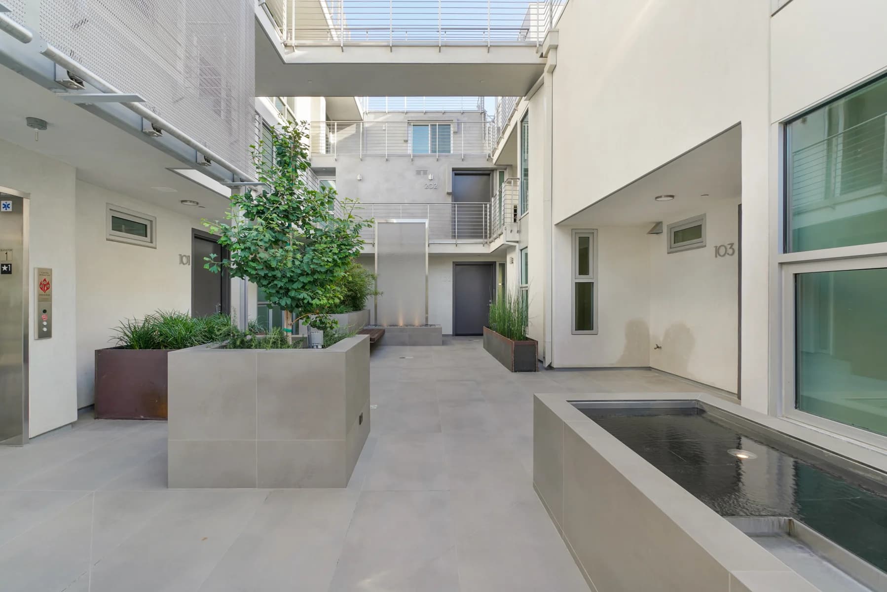 Modern courtyard with a water feature and planter boxes. (photo 2 of 11)